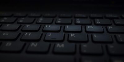 A close-up shot of a modern laptop keyboard with dim lighting, showcasing technology and design.